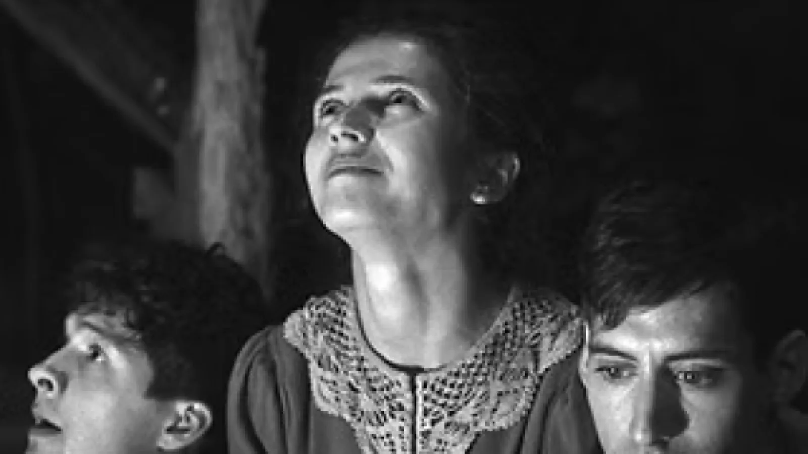 A black and white photo of a woman with a standing between two men